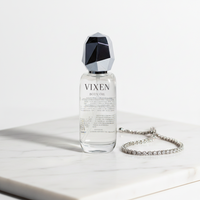 Vixen body oil bottle with a geometric cap on a white surface