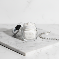 VIXEN cream jar with a silver spoon and bracelet on a marble surface